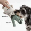Dog biting the Scallion Pal Veggie Pals Crinkle Plush Dog Toy, showing the built-in squeaker and crinkle leaves for interactive play.