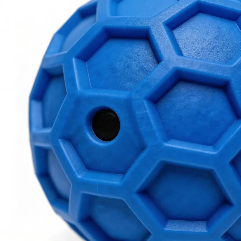 Blue Honeycomb Squeaky Dog Fetch Ball Texture Detail Close-up of the Blue Honeycomb Squeaky Dog Fetch Ball showing the raised honeycomb texture, squeaker hole, and rubber chew surface.