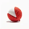 Milky Lychee Squeaky Natural Rubber Dog Chew Toy in a red textured lychee shell with a smooth white center on a clean white background.
