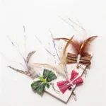 raffia-dragonfly-cat-wand-replacement-color-options Raffia Dragonfly Cat Wand Replacement in Earthy Brown, Blush Pink, and Forest Green with feathers, bells, and shiny streamers.