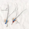 Two blue flying insect cat wand attachments showing peacock feathers, deer hair, blue tinsel, bells, and stainless steel snap clasps.
