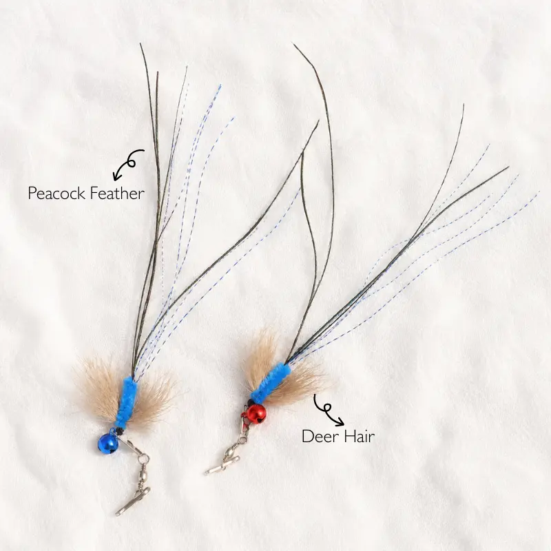 Two blue flying insect cat wand attachments showing peacock feathers, deer hair, blue tinsel, bells, and stainless steel snap clasps.