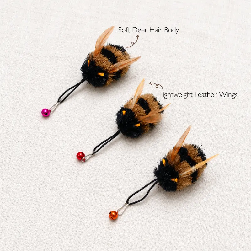 bumble-bee-cat-teaser-toy-material-details-deer-hair-feather-wings Close-up of a bumble bee cat teaser toy showing soft deer hair body, lightweight feather wings, and handmade details for interactive insect cat toy play.