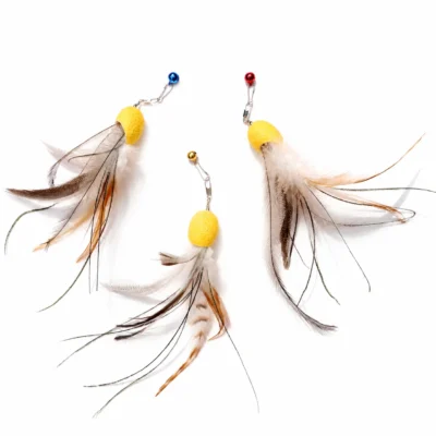 cat-teaser-toy-feather-variations Three cat teaser toy replacement lures with yellow cocoon-shaped bodies, mixed natural feather tentacles, metal clips, and blue, gold, and red bells.