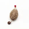 Top view of the Chenille Hedgehog Cat Kicker Toy showing the textured beige chenille body, red plush nose, round eyes, and silvervine fruit attached by a short rope.