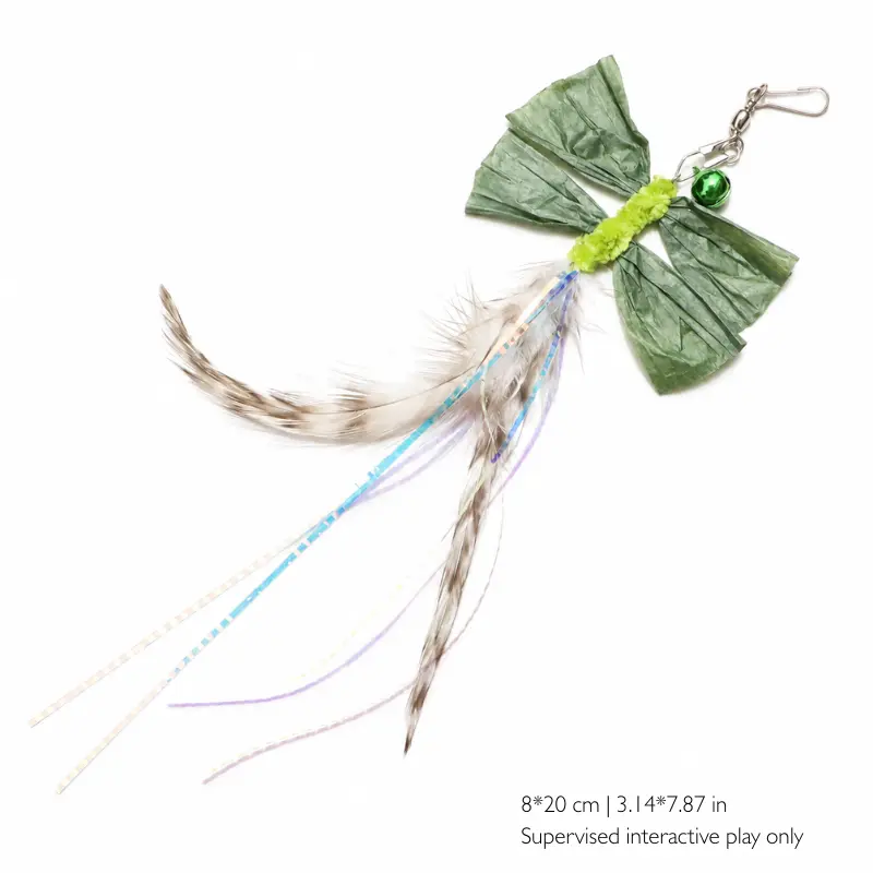 Green raffia wand toy cat with four folded raffia wings, speckled undyed feathers, iridescent strands, a bell and 8 by 20 cm sizing.
