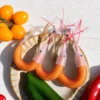 Multiple handmade shrimp cat toy refills displayed together, showing curved orange bodies, chicken feather tails, and colorful whiskers for cat chase toys.