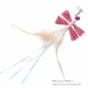 Pink raffia flying bug toy for cats with four raffia wings, undyed feathers, iridescent tail strands, a bell and metal clip, measuring 8 by 20 cm.
