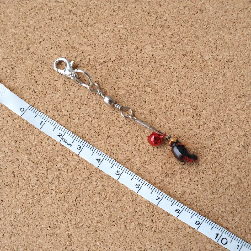 Red Fly cat teaser wand set lure with a small insect-inspired body and colorful details, designed for cat teasing games that encourage chasing and tracking.