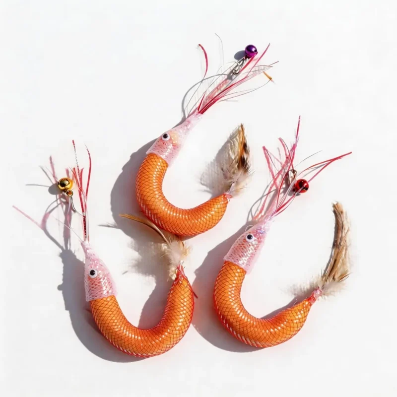 Three orange Wooly Shrimp Cat Wand Replacement refills on a white background, featuring pink shiny silk shrimp antennae, small bell clips, curved wool-filled bodies, and natural feather tails for interactive cat play.
