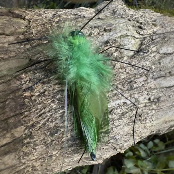Close-up of Emerald Grasshopper Cat Wand Replacement with soft green feathers and realistic bug legs on tree bark
