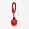 Red Bone Embossed SportLoop Textured Tug Ball Dog Toy with raised bone pattern rubber ball and bungee rope handle, 7 cm by 29 cm