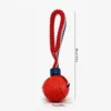 Red Tire Tread SportLoop Textured Tug Ball Dog Toy with rubber tire texture ball and red bungee tug handle, 7 cm by 29 cm
