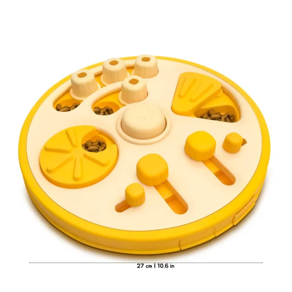 A yellow Busy Bites Dog Enrichment Puzzle Feeder with hidden kibble compartments, sliding pieces, and a 27 cm / 10.6 in size guide.