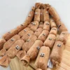 Multiple Sausage Squad 4-Squeak Plush Dog Toys arranged on a wooden surface, showing the long plush sausage shape and playful embroidered faces.