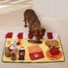 Dachshund sniffing hidden treats on a yellow fast-food snuffle mat with burger, fries, cups, and soft fleece hiding spots.