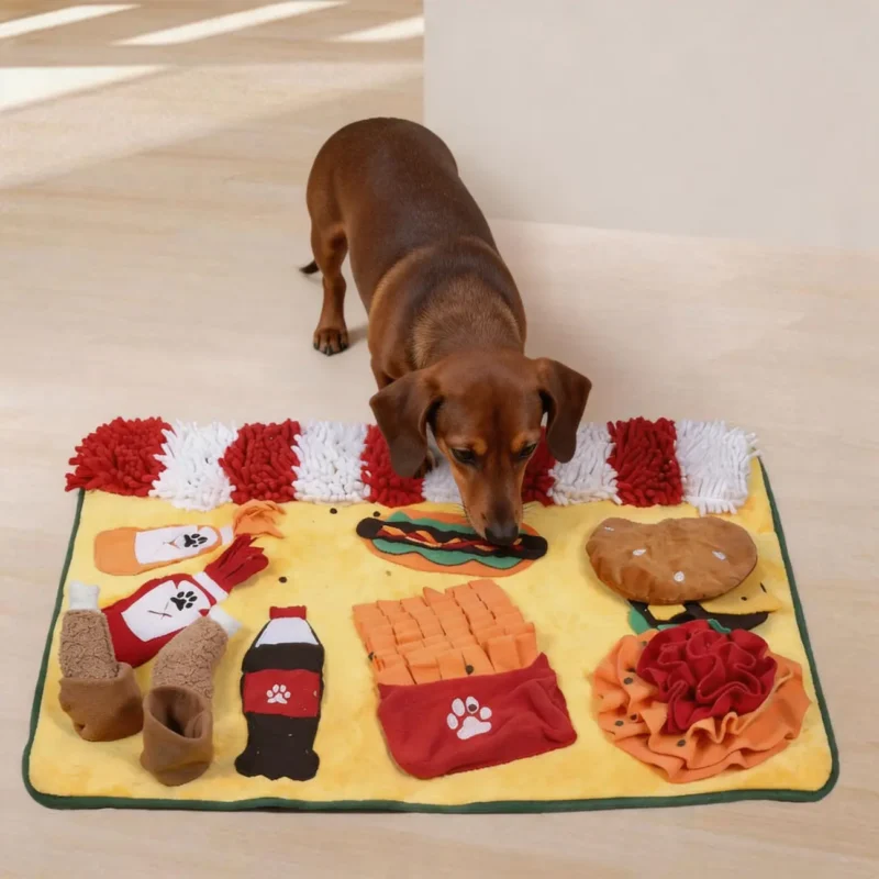 Dachshund sniffing hidden treats on a yellow fast-food snuffle mat with burger, fries, cups, and soft fleece hiding spots.