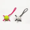Two soft-bite ETPU dog fetch balls with straps on a white background, shown in White with Gray Strap and Lime with Pink Strap.