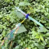 blue-dragonfly-wand-toy-for-cats-outdoors Blue dragonfly wand toy for cats displayed outdoors with reflective crinkle wings and long holographic streamers.