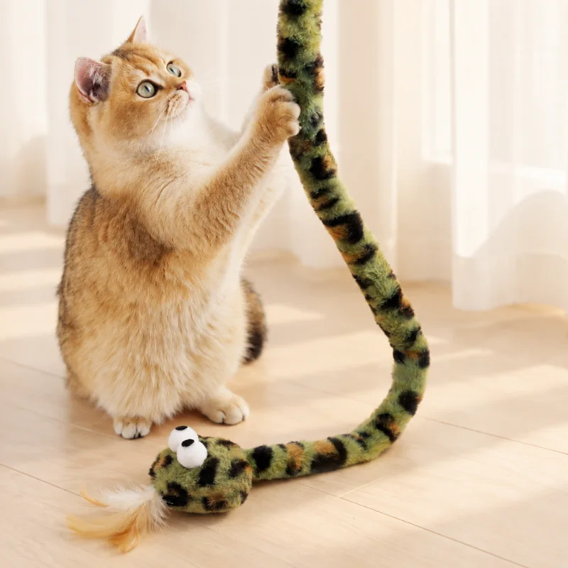 Cat pawing a green snake cat toy with long plush body for interactive grabbing and wrestling play.