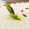 Grasshopper cat toy resting on the floor, designed for cats that like to hunt, stalk, and pounce.