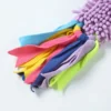 Close-up of colorful blue, pink, yellow, purple, and green fleece strips attached to the Lavender Purple chenille fabric body of a mop dog toy.