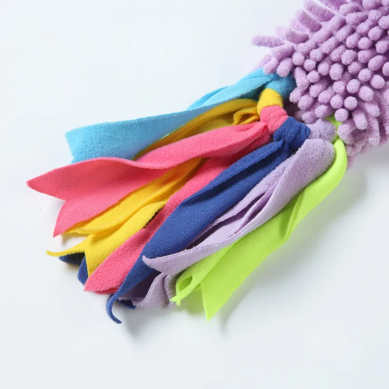 Close-up of colorful blue, pink, yellow, purple, and green fleece strips attached to the Lavender Purple chenille fabric body of a mop dog toy.