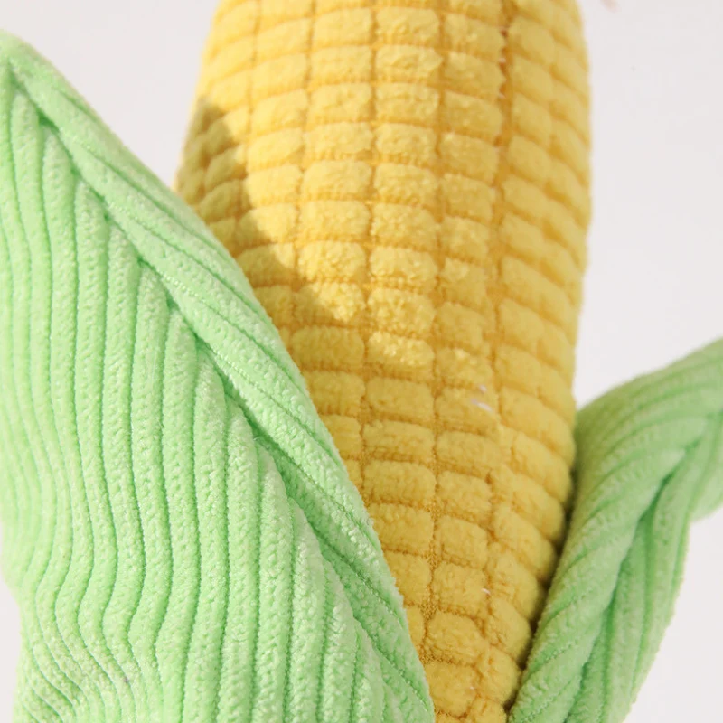 corn-plush-dog-toy-corduroy-texture Close-up of a corduroy plush toy for dogs, showing the ribbed texture of the golden corn cob and soft green husks.