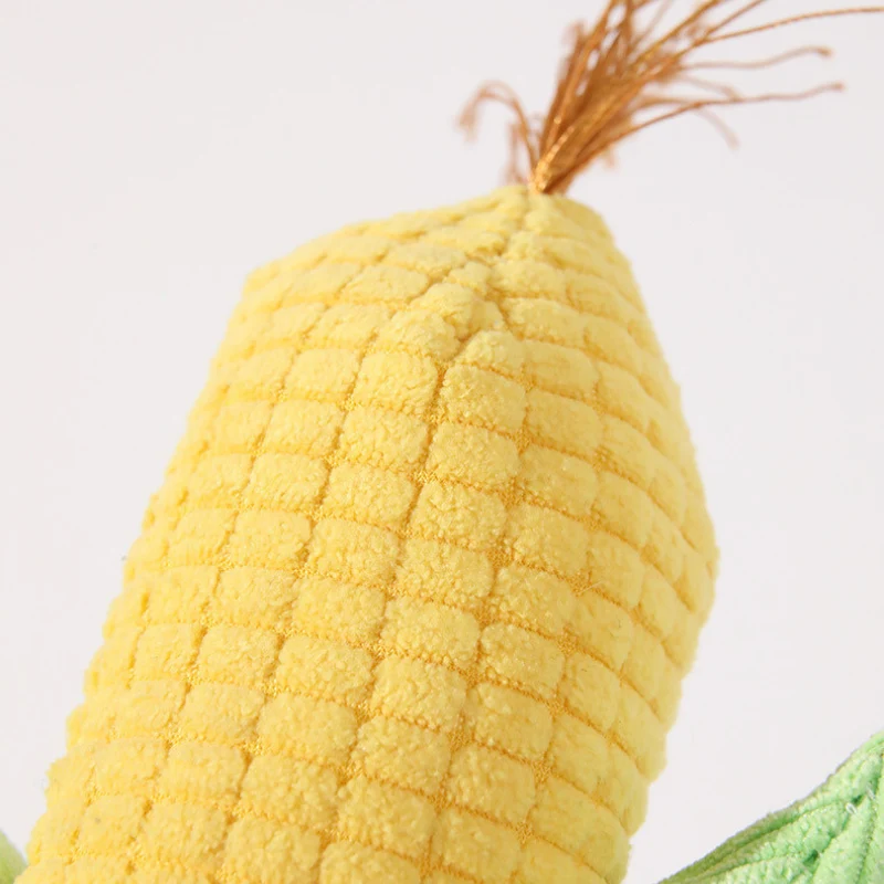 corn-vegetable-plush-tassel-detail Close-up of a golden corn cob and fine golden-orange tassel on a vegetable plush dog toy, with textured fabric resembling fresh corn kernels.