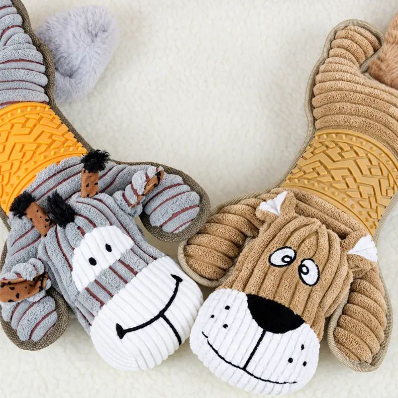 Close-up of the gray donkey and tan dog, two cuddly stuffed animals with corduroy plush bodies, floppy ears, and embroidered smiles.