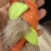Close-up of soft faux fur and fleece strips woven into an orange dog tug toy, highlighting the textured bite area for interactive play.