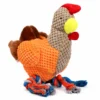 Orange chicken plushy dog toy with a round textured body, soft brown wings, bright red comb, yellow beak, and colorful knotted rope legs.